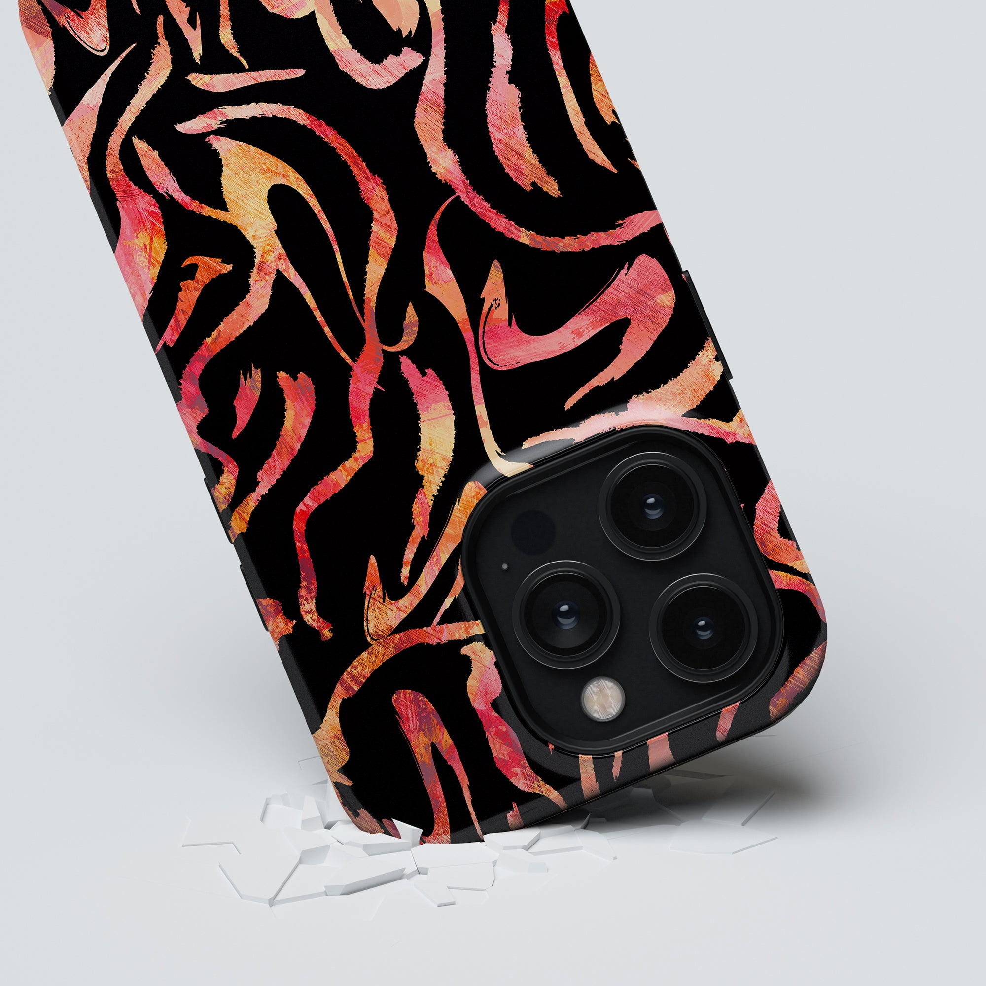 A Burning Stripes - Tough case, characterized by its black and pink abstract-patterned design giving it a "trendigt utseende," encases a smartphone, which rests on a white surface scattered with broken glass pieces underneath.