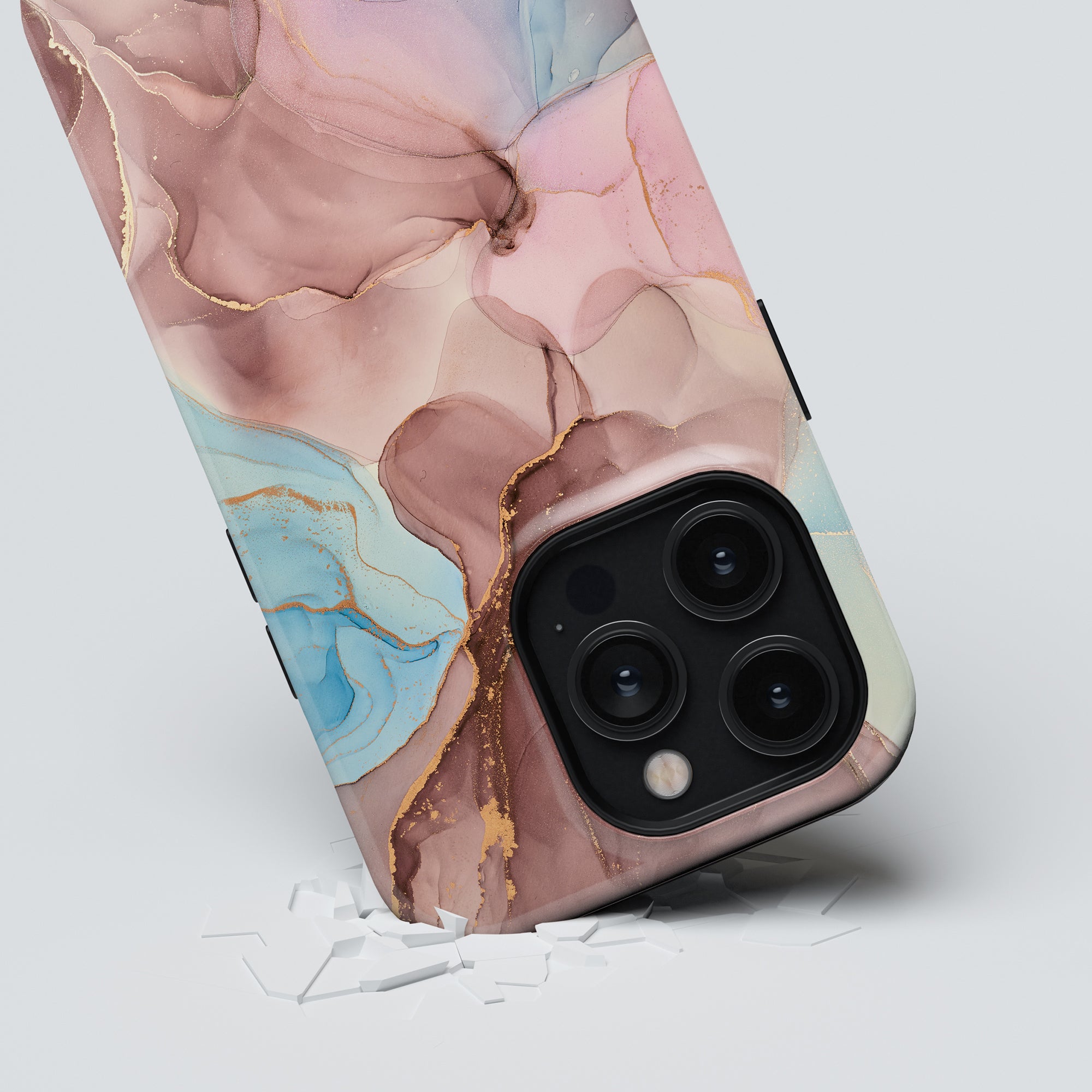 The Marvellous - Tough Case from the Roar Sweden Marble Collection, showcasing a marble-patterned design in shades of pink, blue, and beige with gold accents, rests on a white surface. The sturdy case effectively guards the triple camera lens visible in the corner.