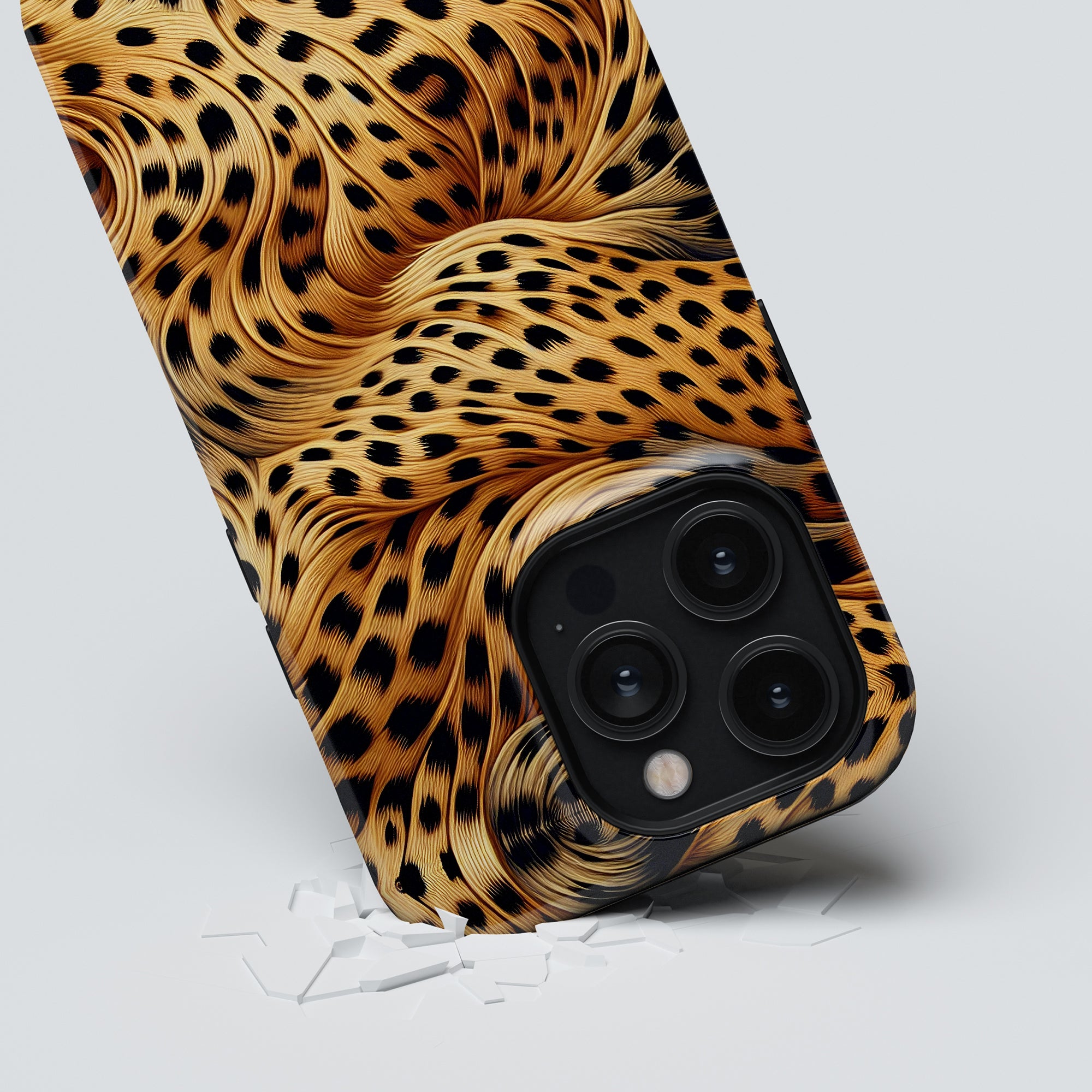 A smartphone fitted with the Wavy Leopard - Tough case is positioned upright on a white surface, revealing small cracks around its base. The rear camera lenses are also visible.